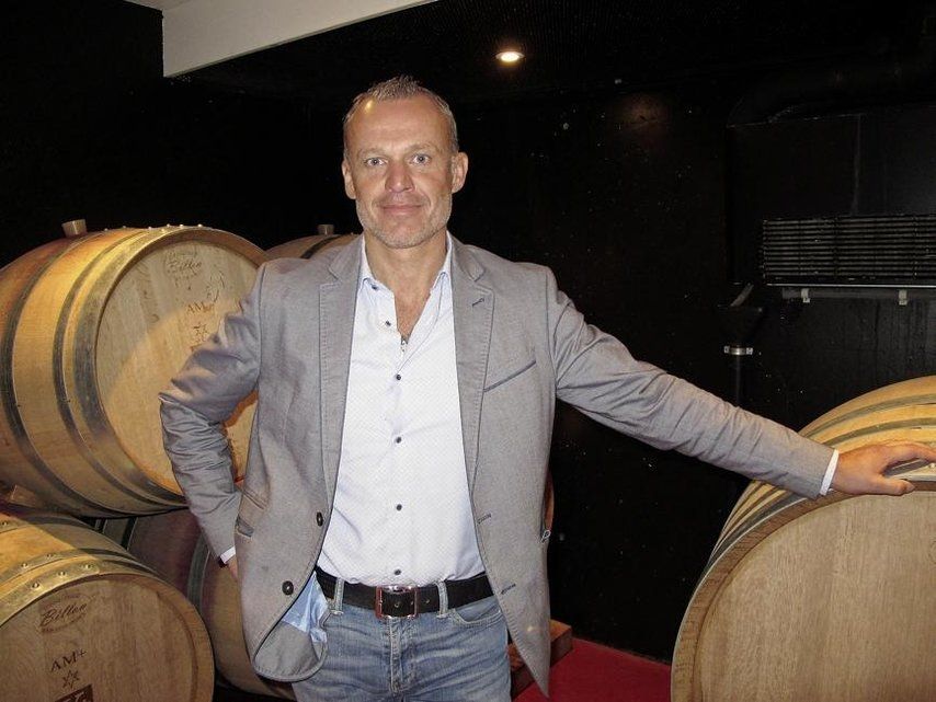 Jean-Luc Kursner in a cellar, among barrels